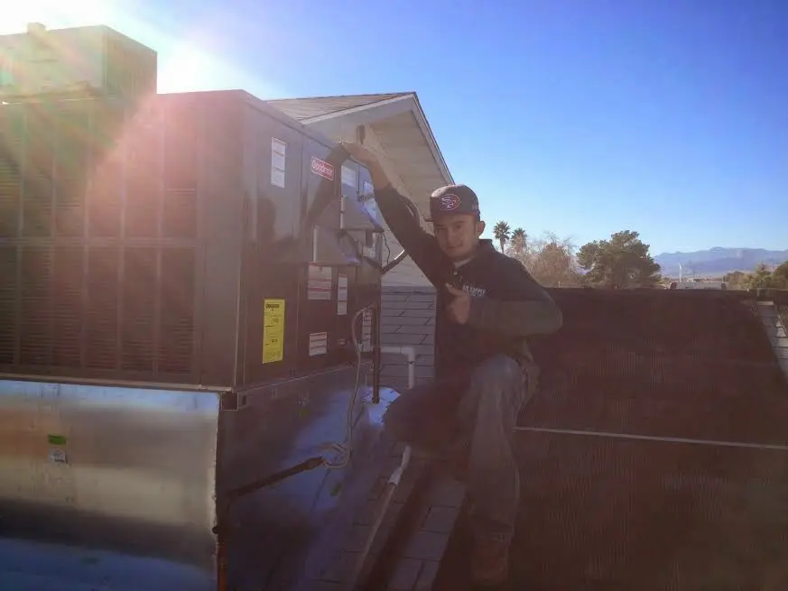 HVAC technician performing Boiler Repair on a rooftop unit in Brier